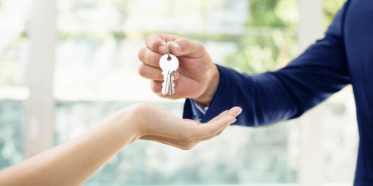 Real estate agent handing over the keys to a new house after a home inspection